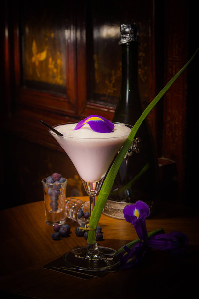 cocktail with a flowers on a wooden table - Foto, imagen