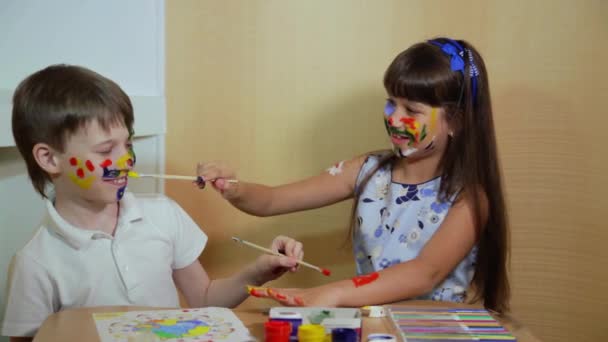 Niños alegres con pinturas en la cara. Dibujo. Concepto de creatividad y educación. Niños pintan caras con colores
.  - Imágenes, Vídeo