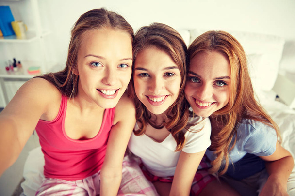 happy friends or teen girls taking selfie at home - 写真・画像