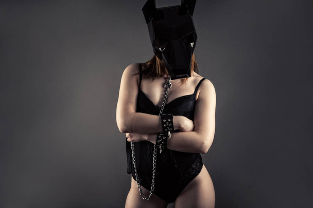 woman slave in dog mask with leash in hands - Foto, afbeelding