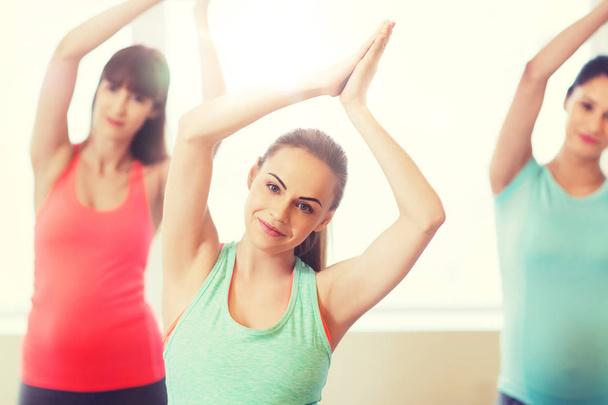 happy pregnant women exercising in gym - Foto, imagen
