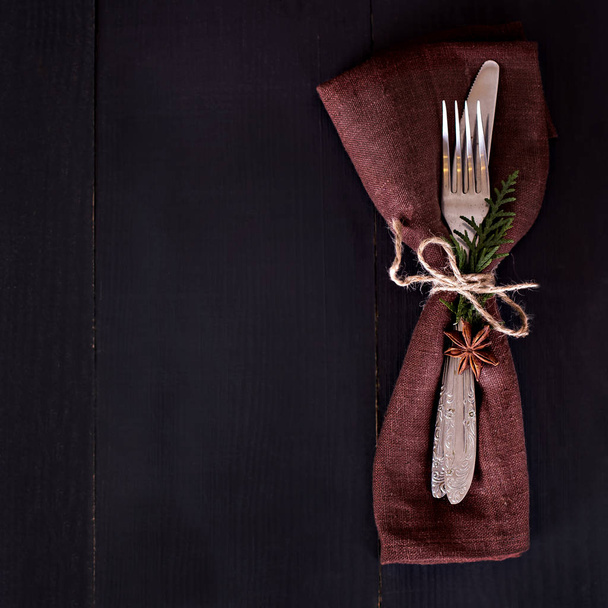 Table setting. Dark photo, brown napkin and cutlery. - Foto, immagini