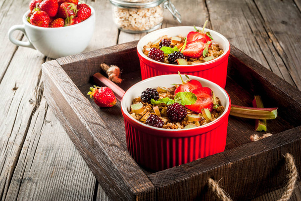 Healthy breakfast. Oatmeal granola crumble with rhubarb, fresh s - Photo, Image