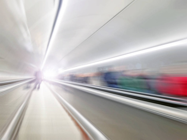 Moviéndose en escaleras mecánicas abstractas por el túnel con la gente
 - Foto, Imagen
