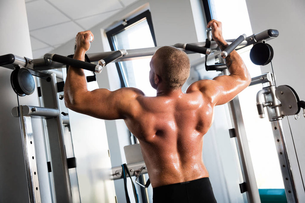 Musculoso hombre fuerte haciendo ejercicio en el gimnasio
 - Foto, Imagen