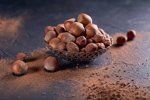 Hazelnut and cocoa powder in dark background.  - Фото, зображення