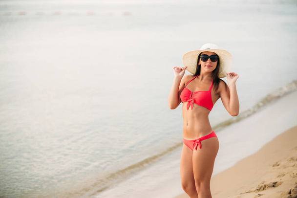 Chica sexy en un traje de baño rosa en la playa. Verano. Clima soleado
. - Foto, Imagen