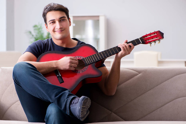 Young man practicing playing guitar at home - Photo, Image