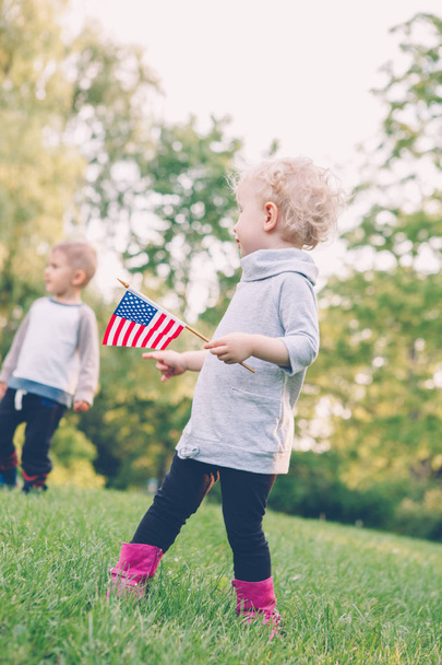 дівчинка і хлопчик, посміхаючись і Махаючи американський і Канадський прапори - Фото, зображення