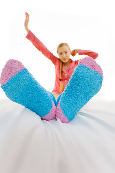 Woman in pajamas wearing furry warm socks - Foto, imagen