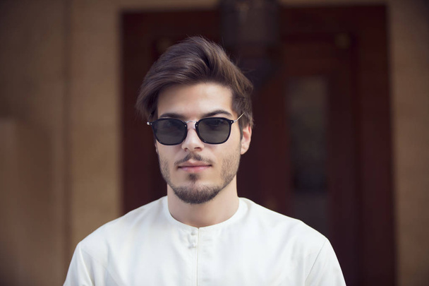 schöner arabischer junger Mann mit Kandura und Sonnenbrille - Foto, Bild