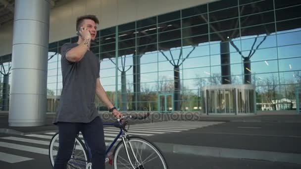 Man holding his bike walking and talking on the telephone slow motion - Metraje, vídeo