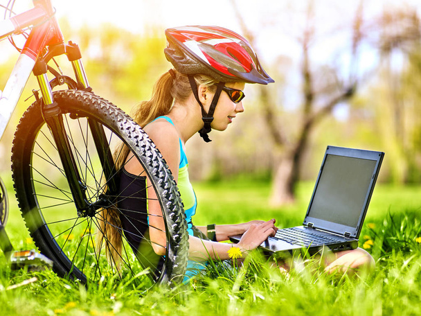 Woman traveling bicycle in summer park. Girl watch laptop. - Photo, Image