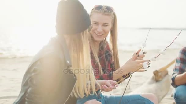 Two attractive blondes string marshmallows on twigs and laugh close-up. - Footage, Video
