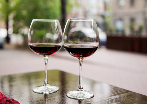 Два бокала с красным вином в кафе
 - Фото, изображение