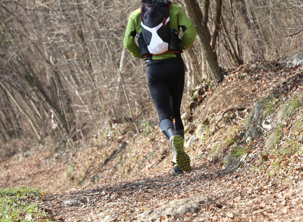 Спортсмен, бегущий сзади в спортивной одежде во время гонки
 - Фото, изображение