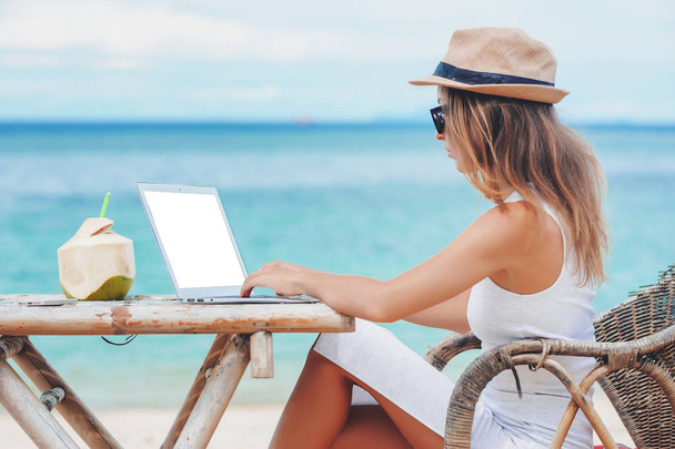 Young woman using laptop on the beach. Freelance work - Foto, Imagem