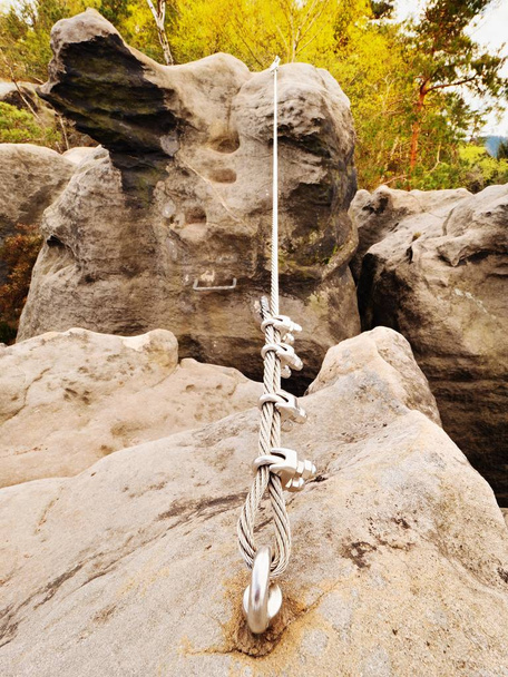 Cuerda retorcida de hierro estirada entre rocas en parche escaladores vía ferrata. Cuerda fijada en roca
 - Foto, imagen