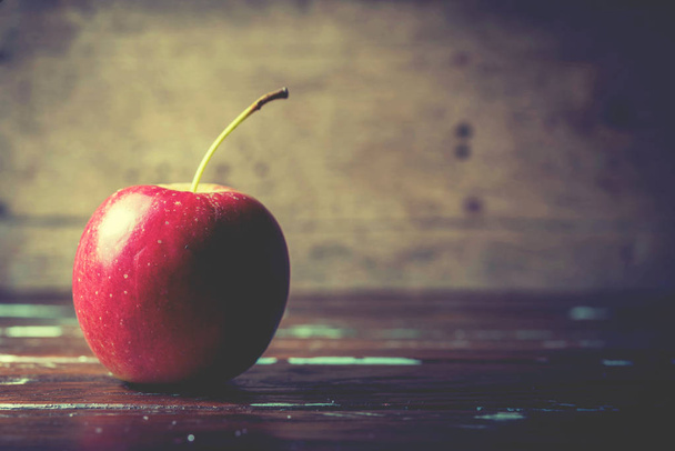única maçã vermelha sozinha no fundo de madeira
 - Foto, Imagem