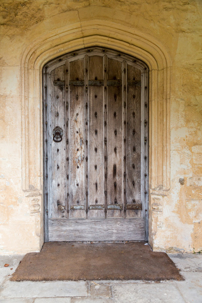 Antigua puerta de madera de roble rodeada de piedra
 - Foto, imagen