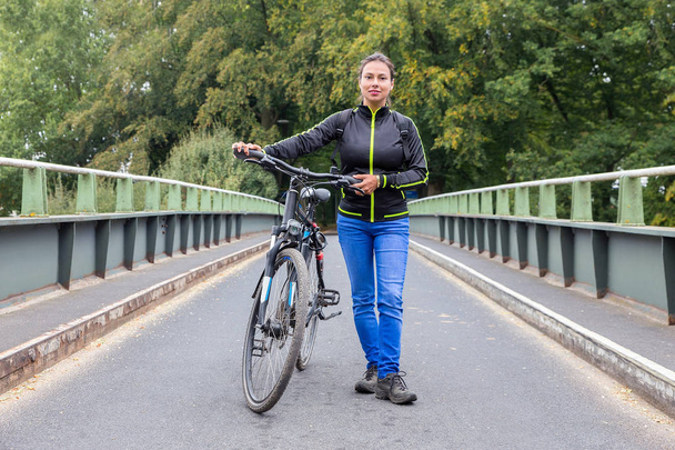 Kobieta trzyma rower górski Atb na most - Zdjęcie, obraz