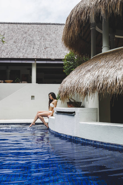 Γυναίκα απολαμβάνει διακοπές κοντά σε πισίνα - Φωτογραφία, εικόνα