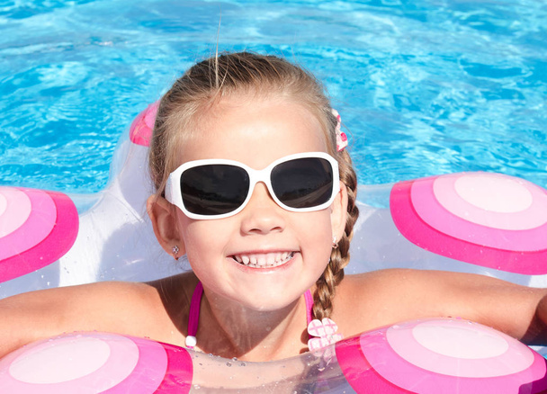 Smiling little girl in swimming pool  - Foto, Bild