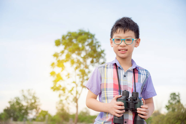 boy holding binoculars in forest - Zdjęcie, obraz