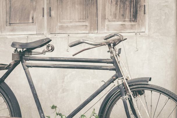 Régi rozsdás vintage kerékpár áll közel betonfal - Fotó, kép