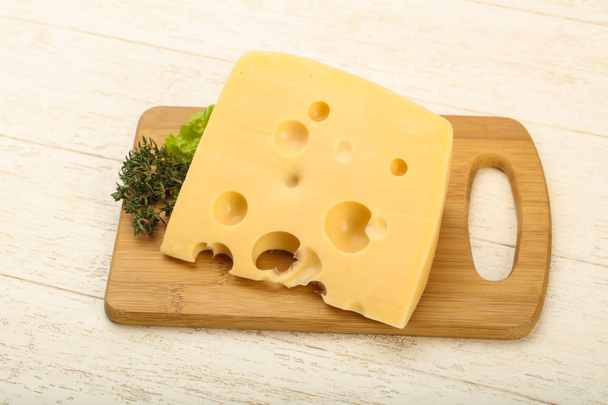 Piece of tasty cheese over the wooden plate - Photo, Image