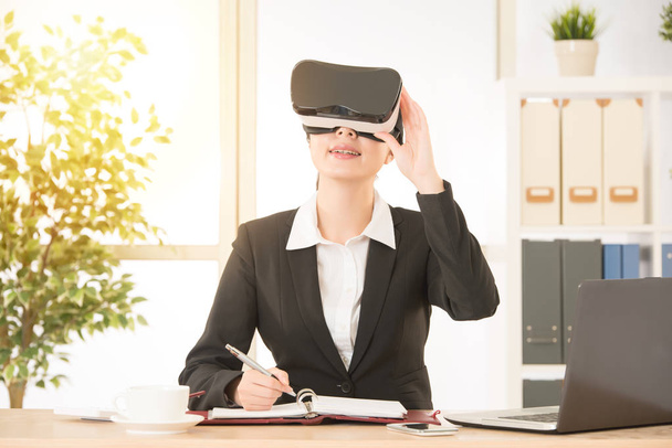 joyful businesswoman holding VR goggles  - Foto, Imagen