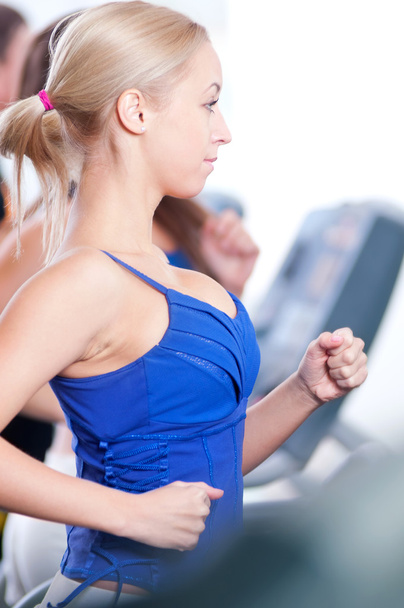 Two young women run on machine in the gym - Foto, Imagem