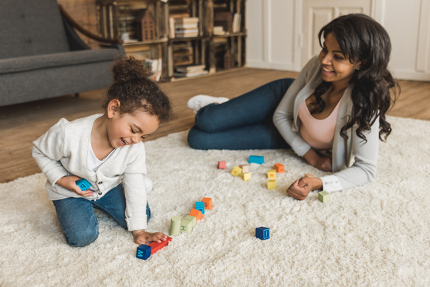mother and daughter playing with cubes - 写真・画像