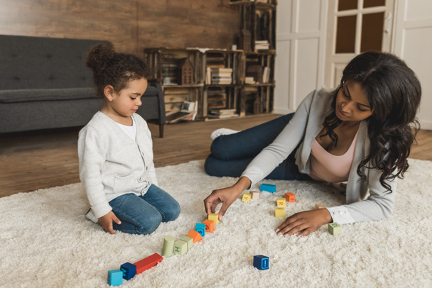 moeder en dochter spelen met kubussen - Foto, afbeelding