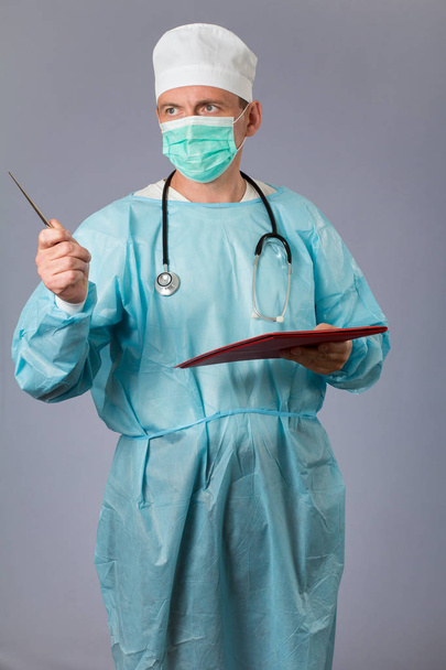 Médico con estetoscopio y mascarilla que sostiene un cuaderno
 - Foto, imagen