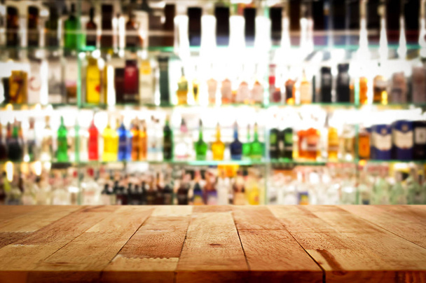 Holz Bar Top auf Unschärfe bunten Alkohol trinken Flasche Hintergrund - Foto, Bild