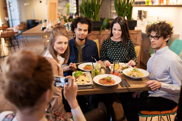 amigos con smartphone fotografiando en el restaurante
 - Foto, Imagen