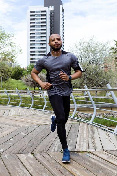 Fit and sporty young man running in the city. - 写真・画像