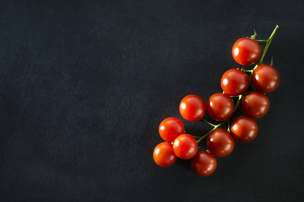 Cherry tomatoes on a dark blue background - Фото, изображение