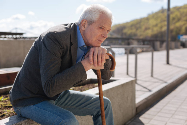 Lonely pensioner observing all around outdoors - Photo, image