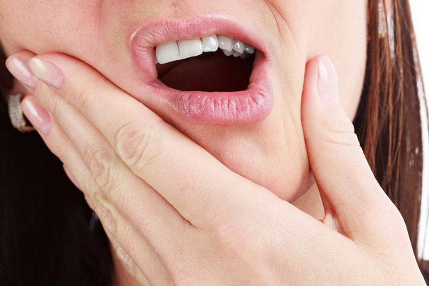 Closeup of woman in strong toothache pain with hands over face.  - Photo, Image