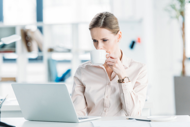 businesswoman working on laptop and drinking coffee - Zdjęcie, obraz