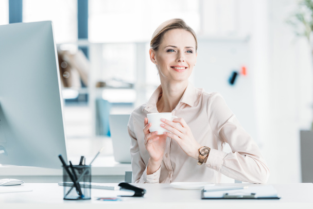 sorridente empresária beber café no escritório
 - Foto, Imagem