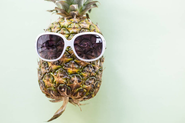 Pineapple wearing sunglasses - Summertime vacation holiday eating healthy concept image - Photo, Image