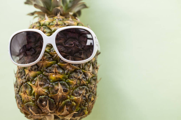 Pineapple wearing sunglasses - Summertime vacation holiday eating healthy concept image - Фото, изображение