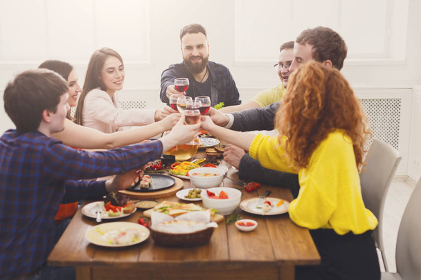 People say cheers clink glasses at festive table dinner party - Photo, Image