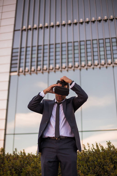 Empresário ajustando seus óculos de realidade virtual
 - Foto, Imagem