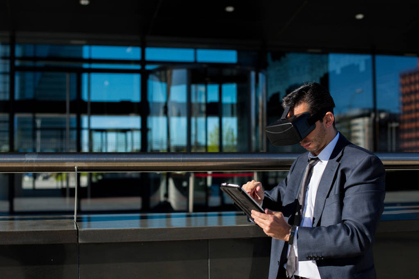 Empresário usando tablet computador e óculos de realidade virtual
 - Foto, Imagem