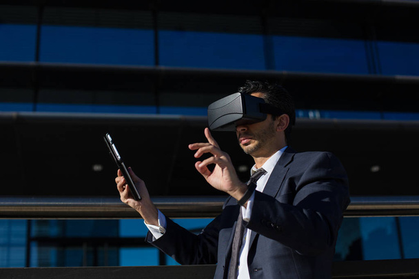 Businessman using tablet computer and virtual reality glasses - Foto, afbeelding