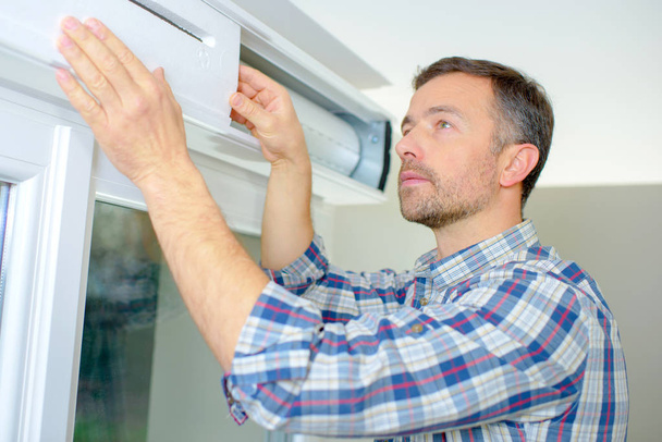 Handyman installing a window shutter - Zdjęcie, obraz